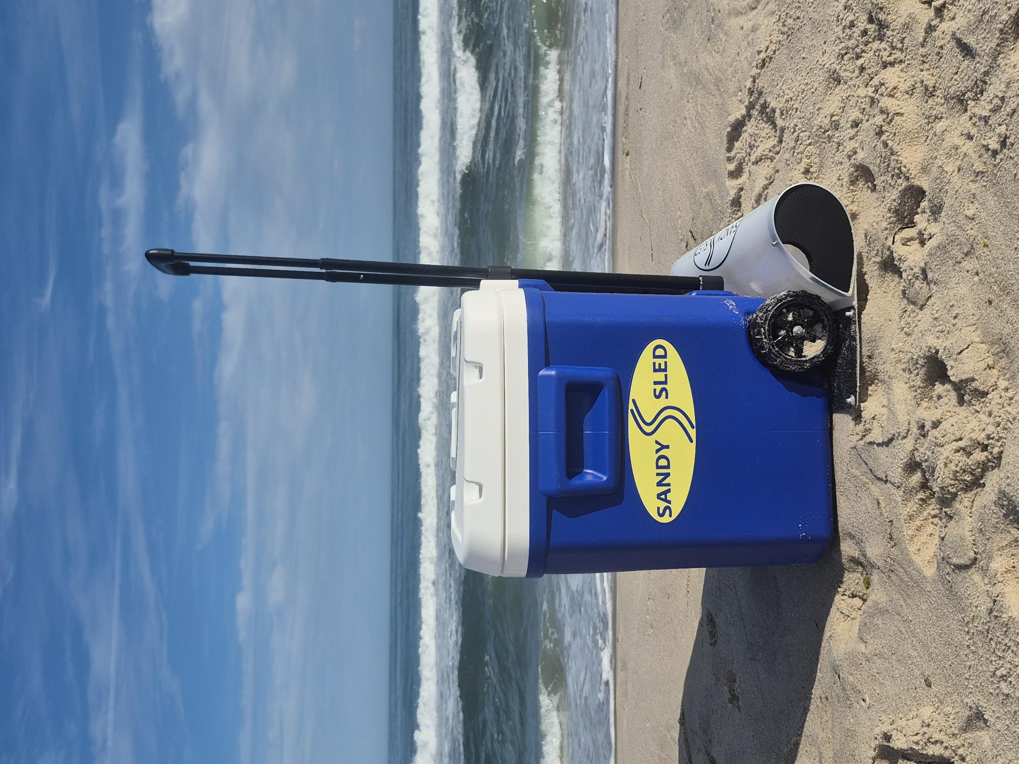 SandySled attached to a blue wheeled cooler on beach sand