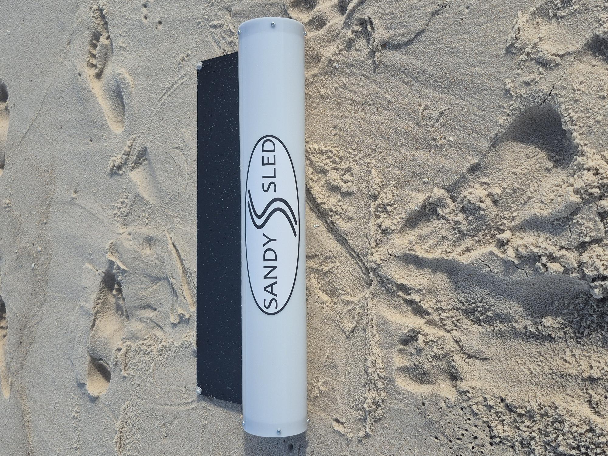 SandySled product shown flat on soft beach sand